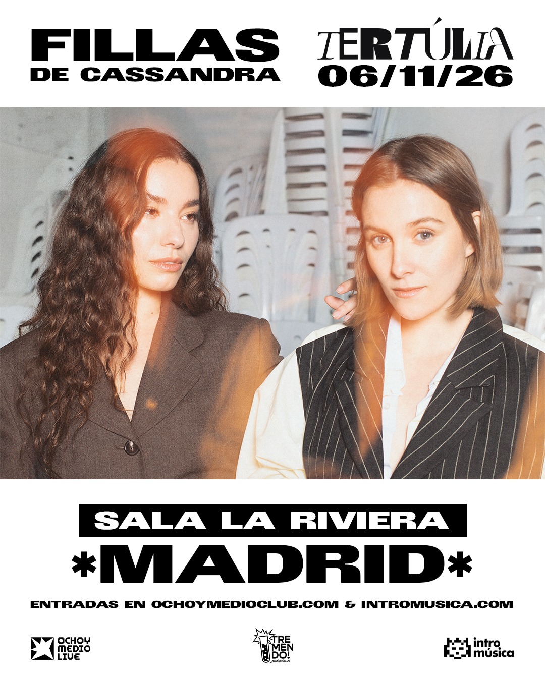 Event poster: two women in blazers foreground; bold text reads 'FILLAS DE CASSANDRA' and 'TERTULIA 06/11/26' with 'SALA LA RIVIERA MADRID' and ticket links at the bottom.